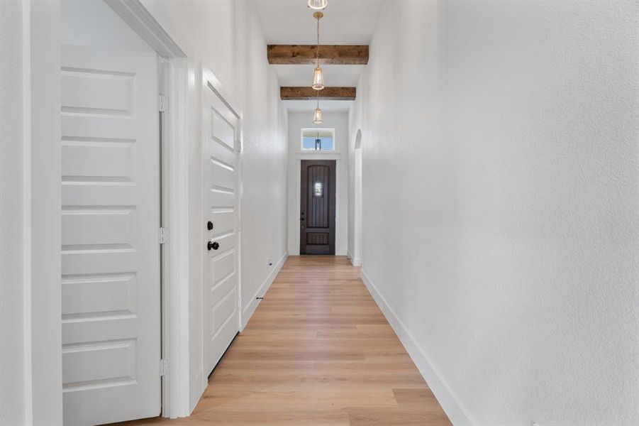 Hall with beamed ceiling and light wood finished floors