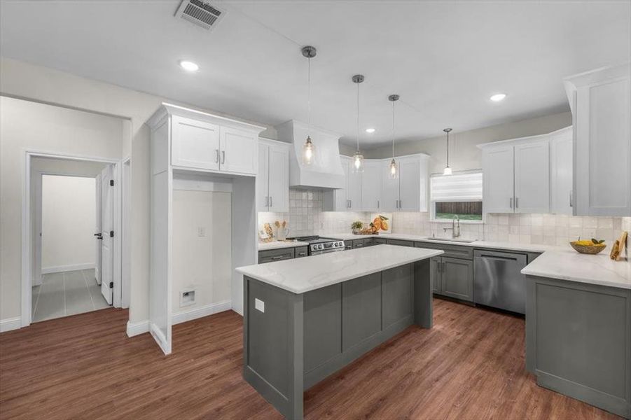 Kitchen with white cabinetry, sink, stainless steel appliances, and a kitchen island