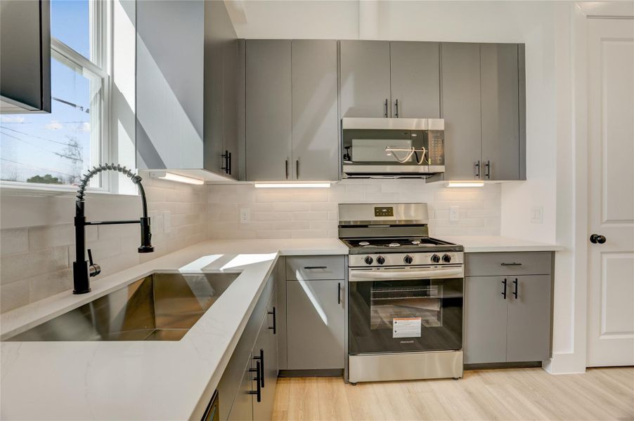 The kitchen island has a stainless steel undermount Kohler sink with retractable faucet and drip accessories.
