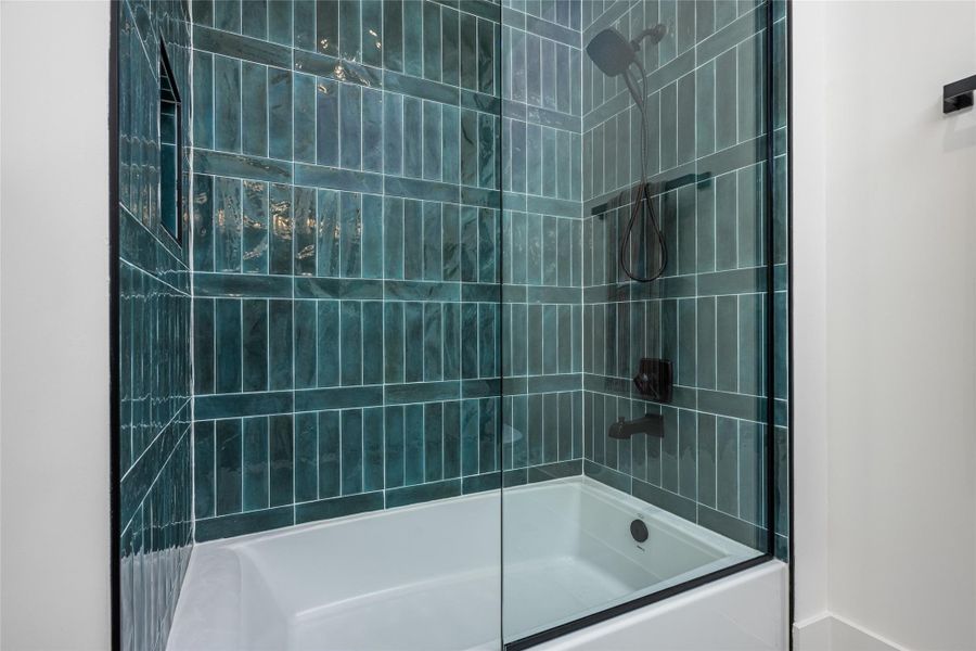 The en suite bath features a wide soaking tub, porcelain backsplash, quartz countertops, custom mirrors, and ambient vanity lighting The en suite bath features a wide soaking tub, porcelain backsplash, quartz countertops, custom mirrors, and ambient vanity lighting
