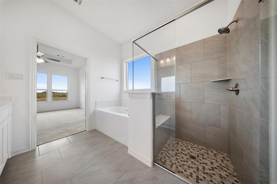 Full bathroom featuring a bath, a tile shower, vanity, light tile patterned floors, and a ceiling fan Full bathroom featuring a bath, a tile shower, vanity, light tile patterned floors, and a ceiling fan