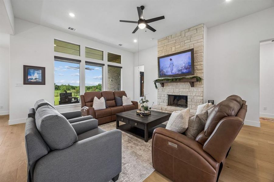 Floor to ceiling stone fireplace and spacious living room bathed natural light.