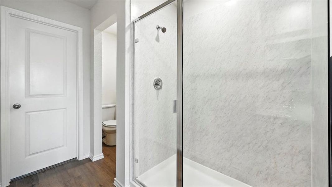 Bathroom featuring a stall shower and dark wood-style flooring