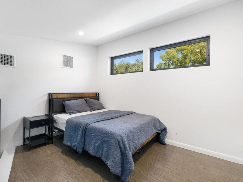 Bedroom with wood finished floors and recessed lighting