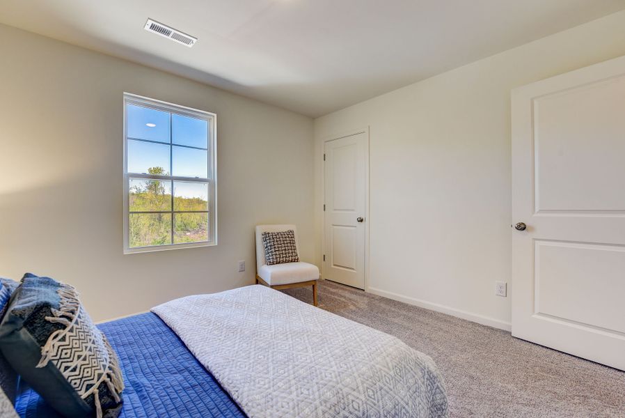 A bedroom with a chair and a bed. A bedroom with a chair and a bed.