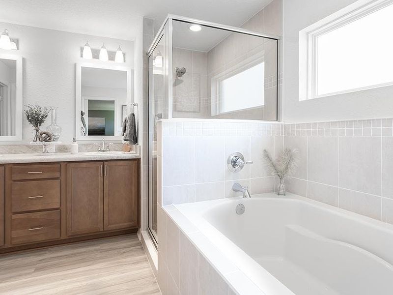 Your suite is complete with a spa-like en-suite bath. Photos showcase a home with similar finishes, not the actual home for sale.