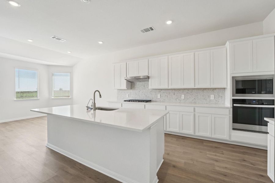 Kitchen with white cabinetry, decorative backsplash, appliances with stainless steel finishes, recessed lighting, and light wood-style floors
