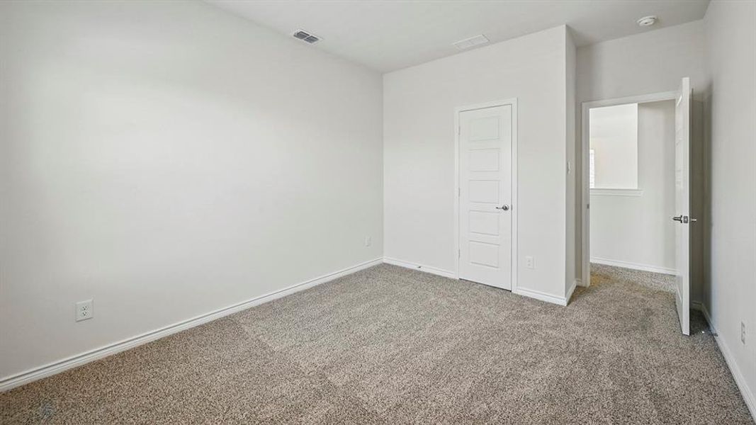 Bedroom with neutral-toned carpet flooring and light-colored walls