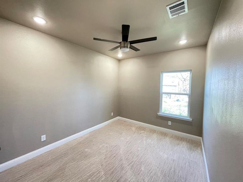 Empty room featuring light carpet and ceiling fan