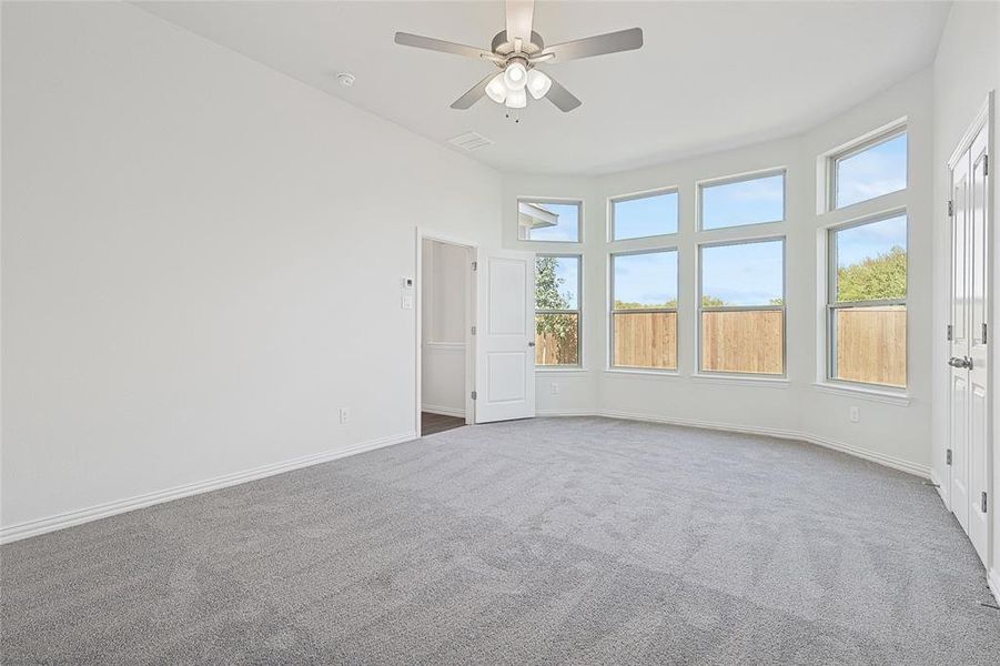 Carpeted spare room with ceiling fan