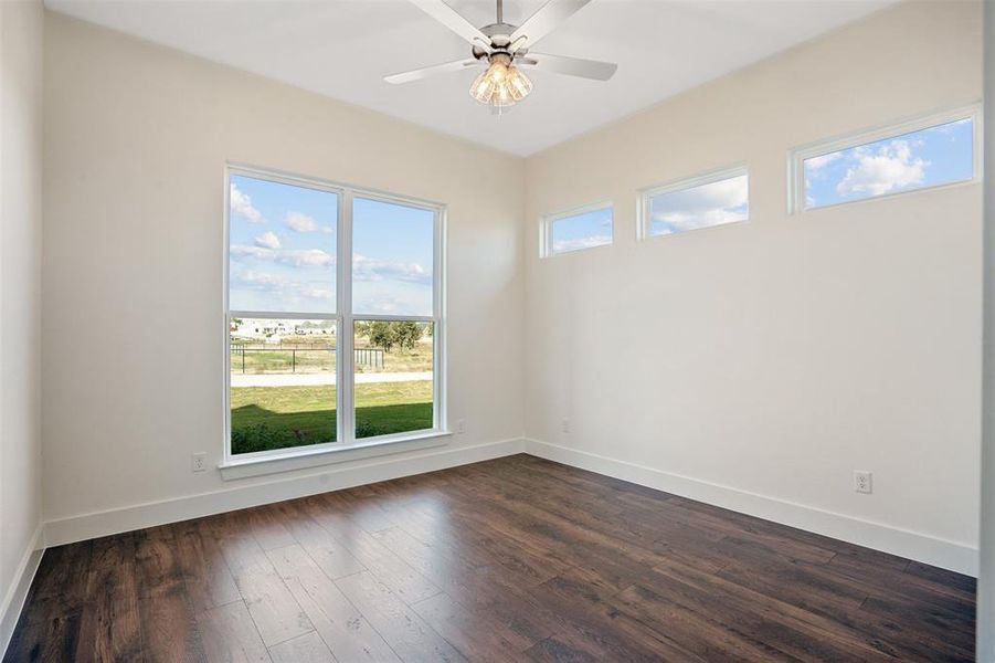 Spare room featuring ceiling fan and dark hardwood / wood-style floors