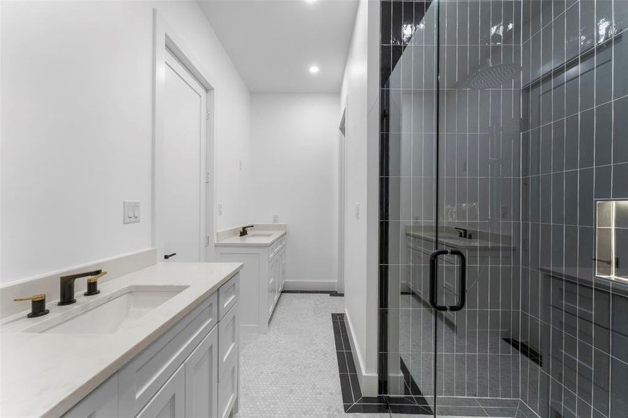Bathroom featuring two vanities, light tile patterned flooring, a shower stall, and recessed lighting