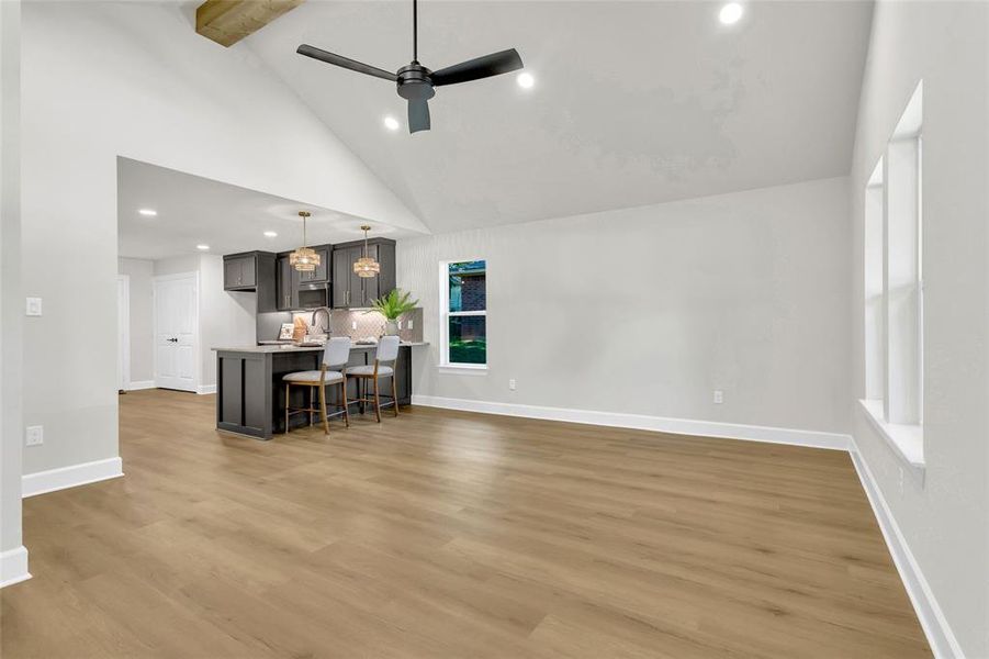 Living area featuring recessed lighting, light wood-style flooring, high vaulted ceiling, ceiling fan, and beamed ceiling Living area featuring recessed lighting, light wood-style flooring, high vaulted ceiling, ceiling fan, and beamed ceiling