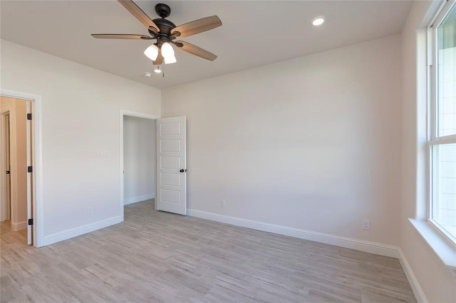 Unfurnished room featuring light wood-type flooring and ceiling fan