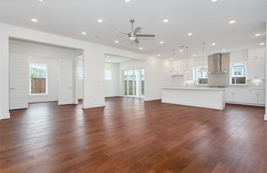 Unfurnished living room with dark wood-type flooring and ceiling fan