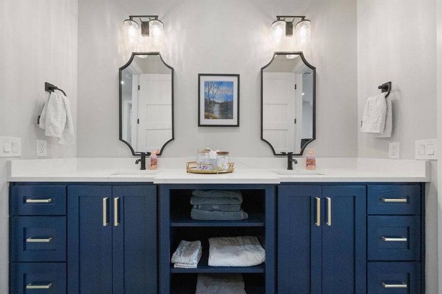 Hall bathroom with double vanity connecting two secondary rooms.