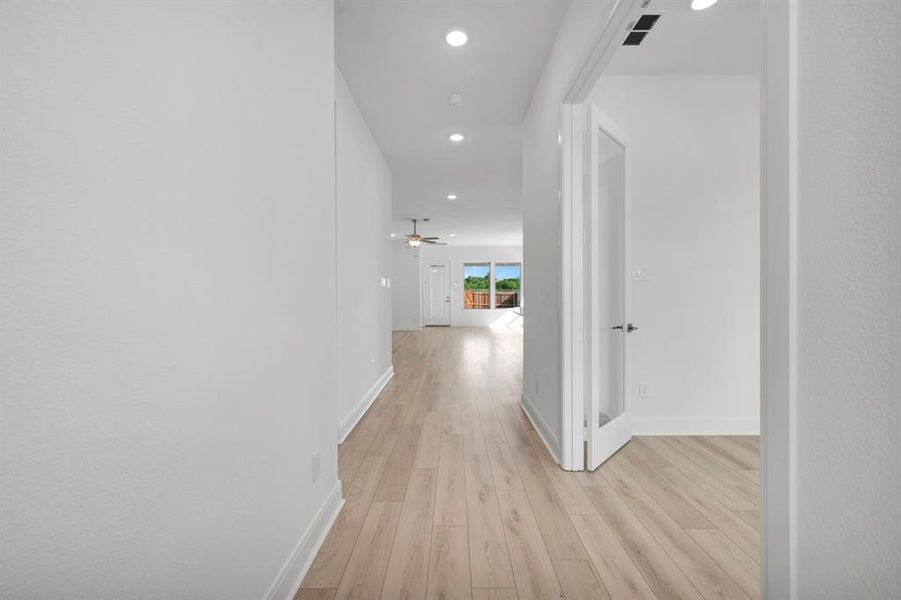 Hall with light wood finished floors and recessed lighting Hall with light wood finished floors and recessed lighting