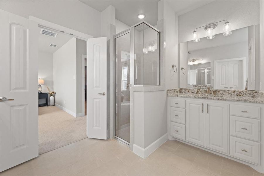 Full bath with vanity, a shower stall, ensuite bath, and light carpet