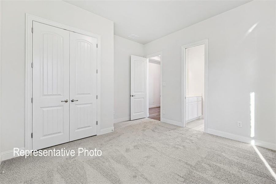 Unfurnished bedroom with light carpet and a closet