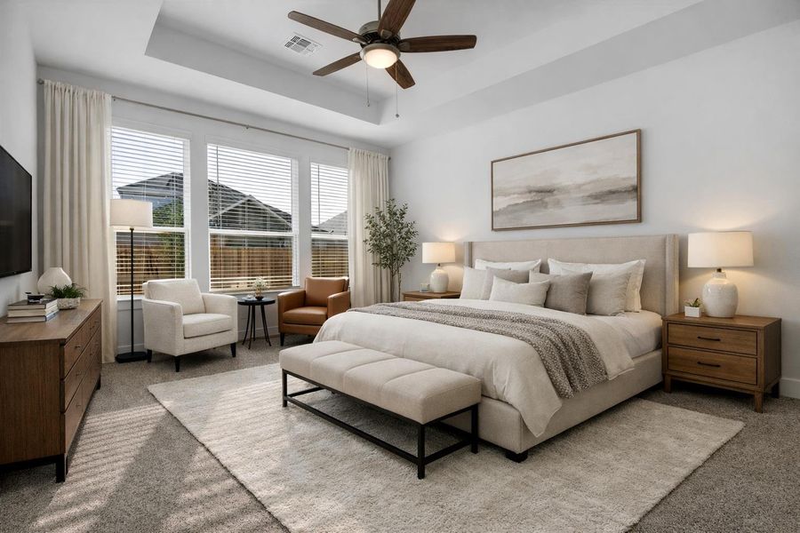 Bedroom featuring carpet, a ceiling fan, and a raised ceiling