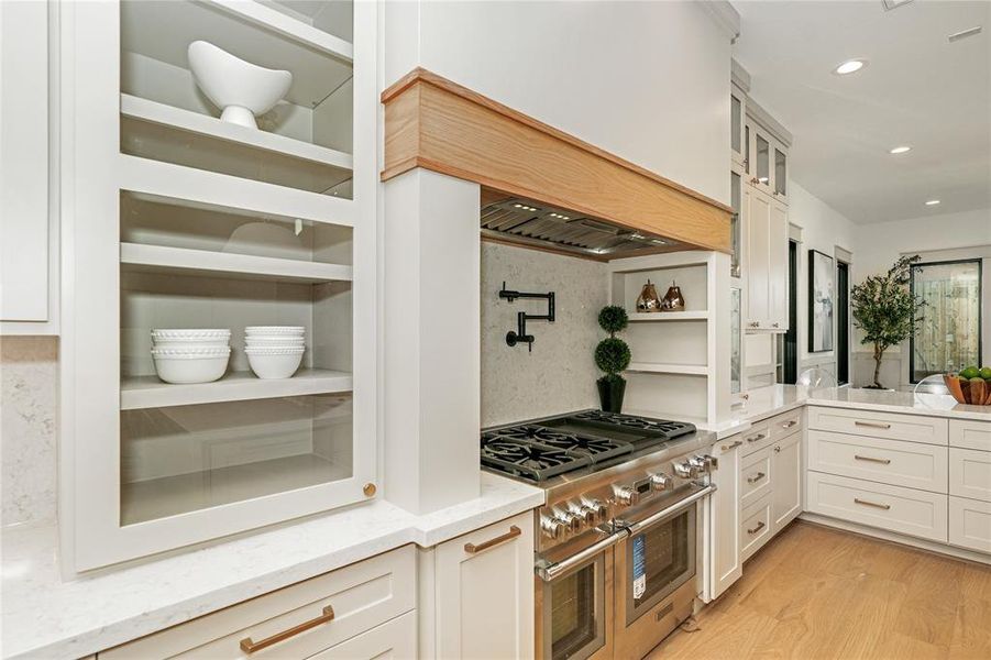 Glass cabinets, extended wide range top, inside storage, pot filler all make this kitchen elegant but functional