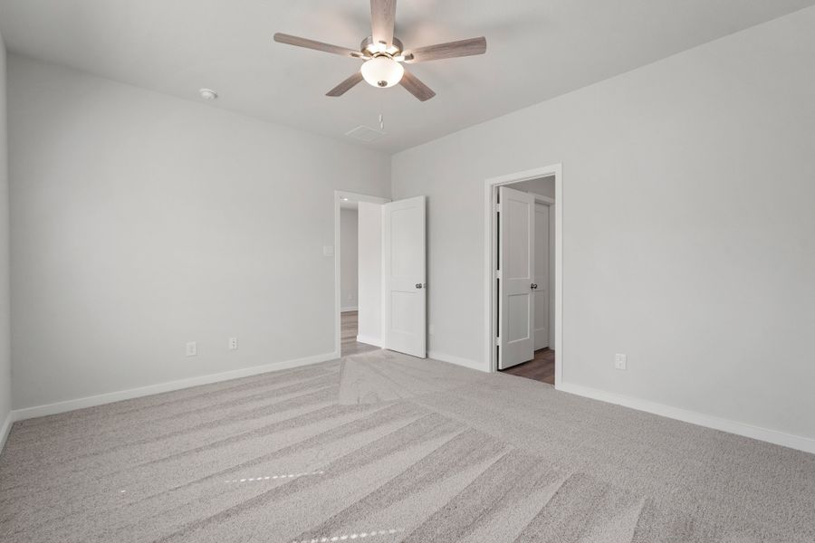 A room with a ceiling fan and a carpet. A room with a ceiling fan and a carpet.