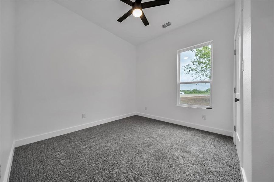 Spare room with dark carpet and ceiling fan