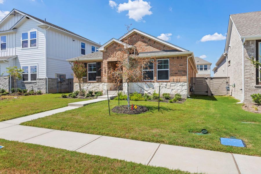 Front exterior of a new home in Flora, Hutto, TX, highlighting curb appeal (Image 20). Front exterior of a new home in Flora, Hutto, TX, highlighting curb appeal (Image 20).