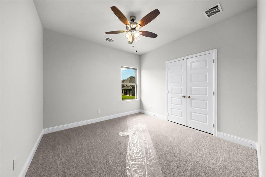Unfurnished bedroom featuring carpet flooring, ceiling fan, and a closet Unfurnished bedroom featuring carpet flooring, ceiling fan, and a closet