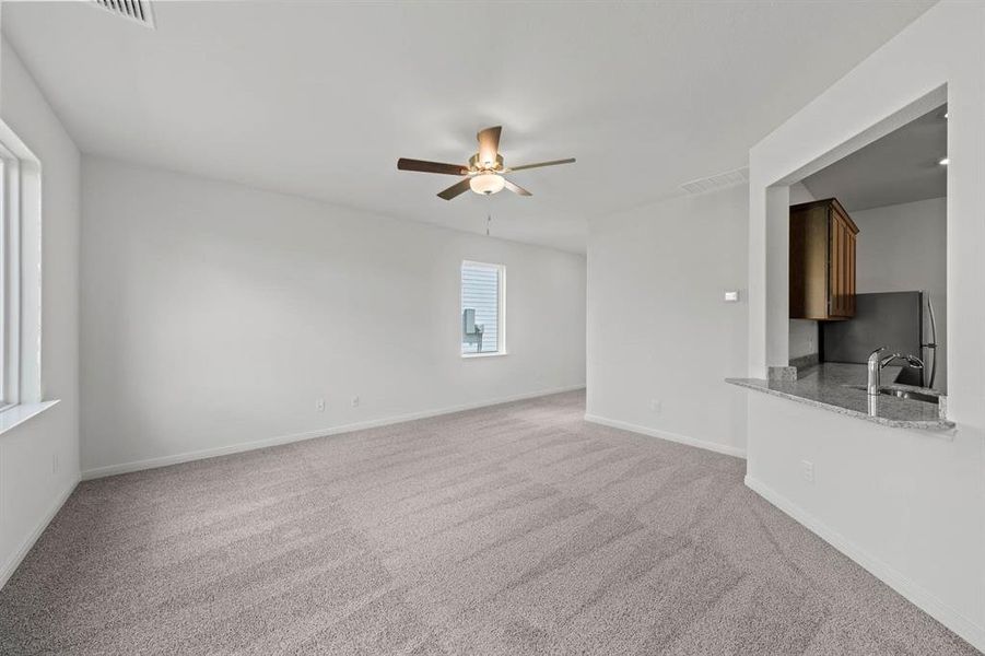 Living room with carpet floors and ceiling fan