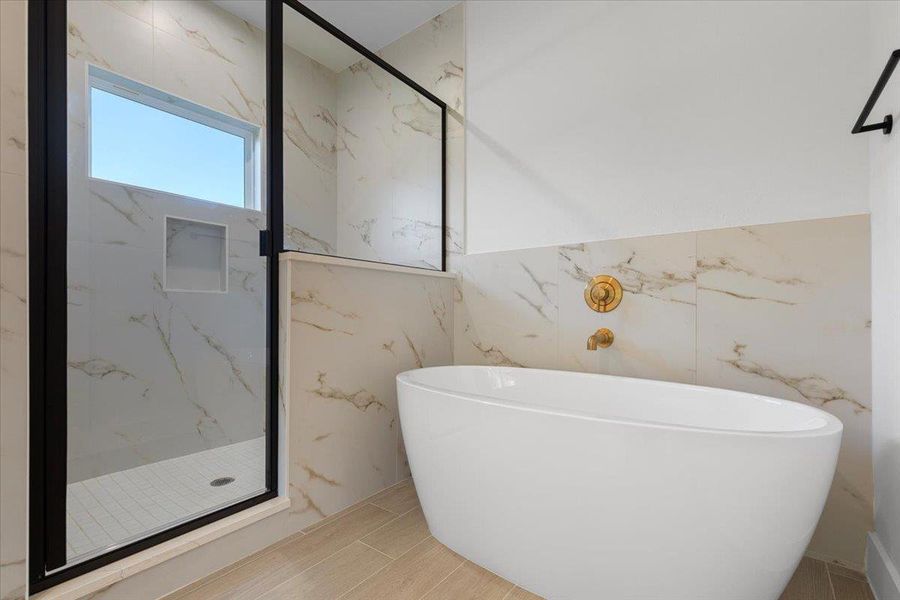 Full bath featuring a freestanding bath and a marble finish shower Full bath featuring a freestanding bath and a marble finish shower