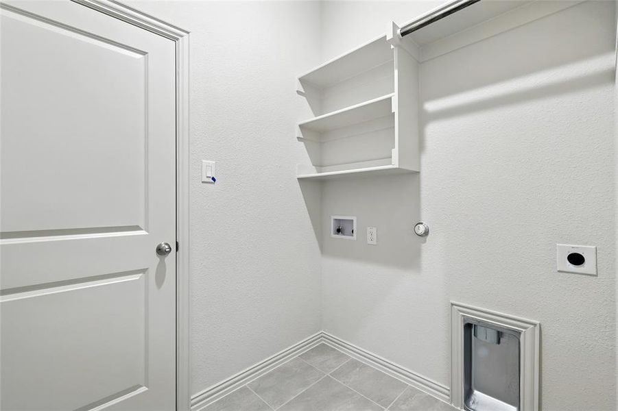 Laundry area with hookup for a washing machine, gas dryer hookup, light tile patterned flooring, and hookup for an electric dryer Laundry area with hookup for a washing machine, gas dryer hookup, light tile patterned flooring, and hookup for an electric dryer