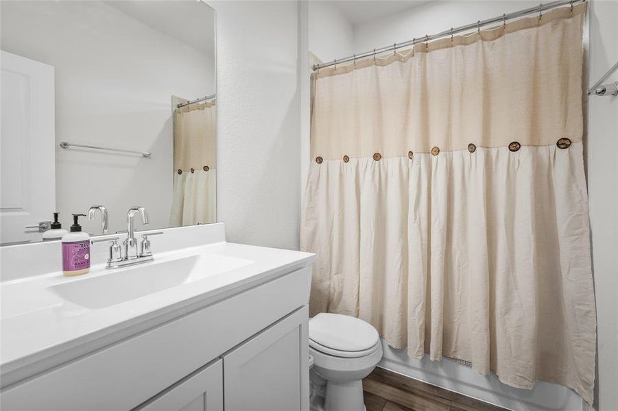 This is the bathroom between the the two secondary bedrooms.  It features a white vanity with a sleek countertop and modern fixtures.