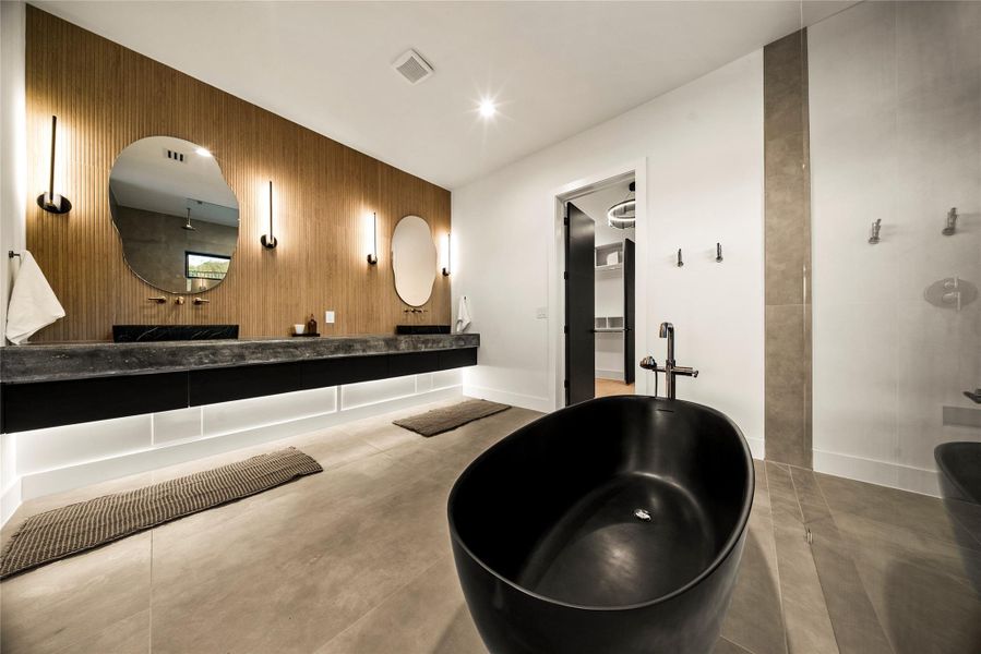 Full bath with walk in shower, double vanity, concrete flooring, a freestanding tub, and wooden walls Full bath with walk in shower, double vanity, concrete flooring, a freestanding tub, and wooden walls
