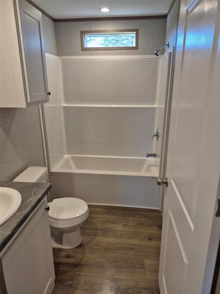 Bathroom with vanity, dark wood-style flooring, and tub / shower combination