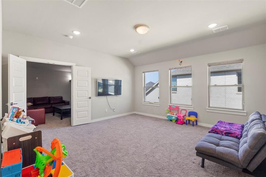 Recreation room with light colored carpet, recessed lighting, and vaulted ceiling