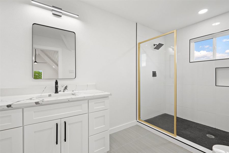 Bathroom with a stall shower, vanity, and recessed lighting Bathroom with a stall shower, vanity, and recessed lighting