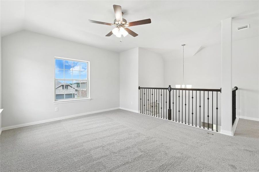 Spare room featuring lofted ceiling, a ceiling fan, and carpet flooring Spare room featuring lofted ceiling, a ceiling fan, and carpet flooring