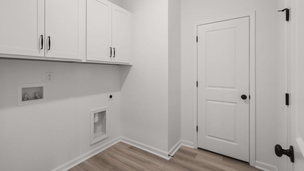 The Easton plan laundry room provides storage cabinets and space for washer and dryer.