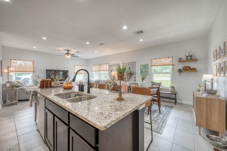 Spacious kitchen island featuring a dual-basin stainless steel sink and granite-finish countertop