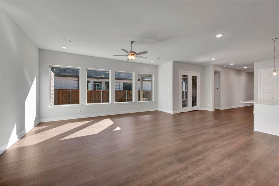 Unfurnished living room featuring a ceiling fan, dark wood-style flooring, and recessed lighting