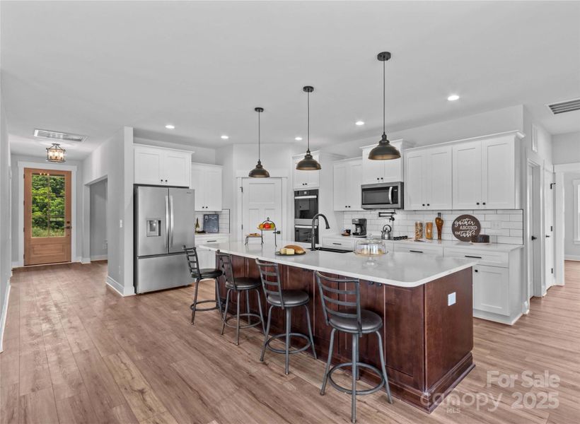 Dream kitchen with 10 ft quartz island, stainless appliances, Pot filler, walk in Pantry.