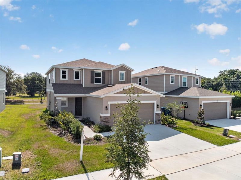 Front exterior of a new home in Seasons at Forest Creek, Haines City, FL, highlighting curb appeal (Image 35).