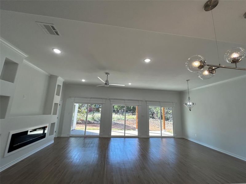 Living room with ceiling fan, crown molding, and dark hardwood / wood-style flooring