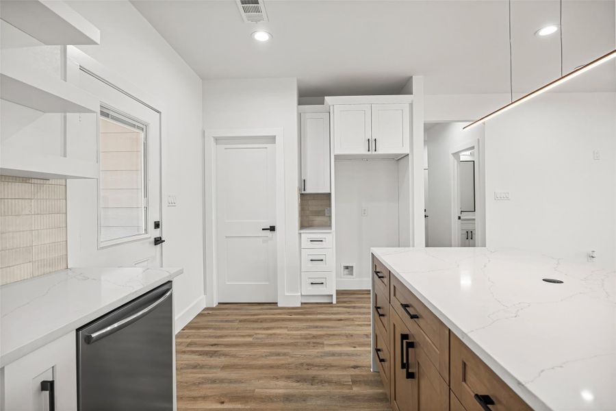 Custom cabinetry with built-in storage, designated refrigerator space, and nearby pantry access.