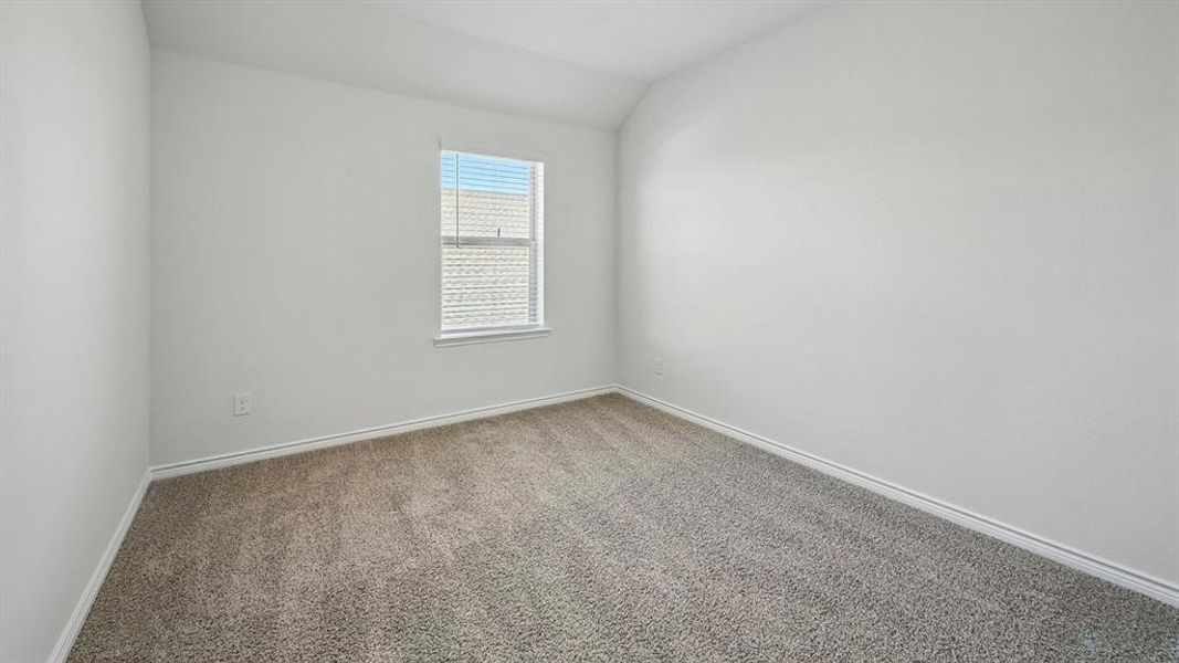 Neutral white walls featuring a single window with horizontal blinds and textured gray carpeting Neutral white walls featuring a single window with horizontal blinds and textured gray carpeting
