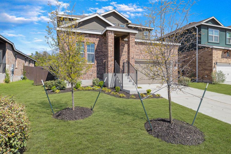 Craftsman-style home featuring concrete driveway, a front lawn, brick siding, and an attached garage