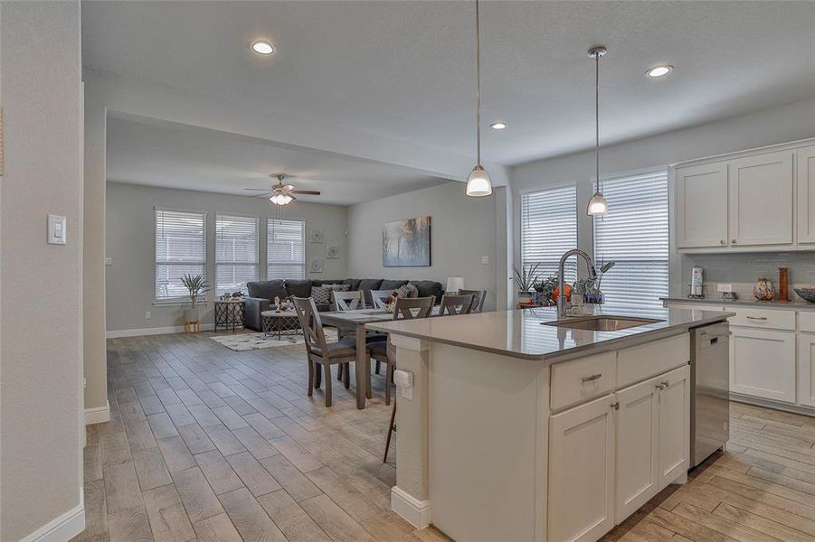 Kitchen with light wood-style flooring, white cabinets, tasteful backsplash, and recessed lighting Kitchen with light wood-style flooring, white cabinets, tasteful backsplash, and recessed lighting