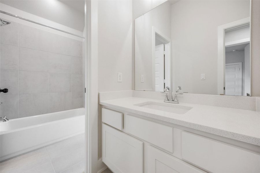 Full bathroom featuring vanity, light tile patterned flooring, and bathtub / shower combination
