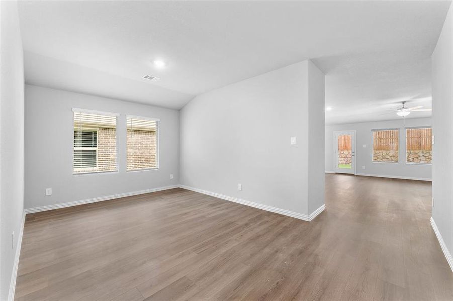 Spare room featuring healthy amount of natural light, wood finished floors, and ceiling fan Spare room featuring healthy amount of natural light, wood finished floors, and ceiling fan
